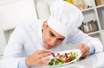 Young man is evaluating prepared dish