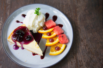 Colorful New York cheese cake with well decorated fruit pieces and whipped cream in white plate - cake recipe menu concept
