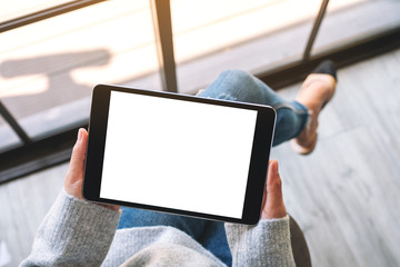 Top view mockup image of a woman holding black tablet pc with blank white screen