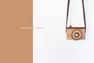 Wooden toy camera on pastel background.