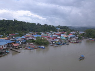 Kuching, Sarawak / Malaysia - November 18 2019:  The scenery of a traditional fishing village at Kuching, Sarawak, Malaysia. With the fishing boats along the Sarawak River and the villages on both sid