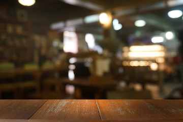 Empty dark wooden table in front of abstract blurred bokeh background of restaurant . can be used for display or montage your products.Mock up for space.