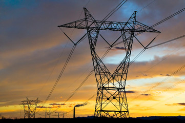 Power Pylons and Electricity transmission wires with clouds at sunset
