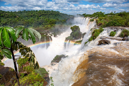 Spectacular view with rainbow from top of the waterfalls to gorge and San Martin Island, Iguazu Falls, Argentina