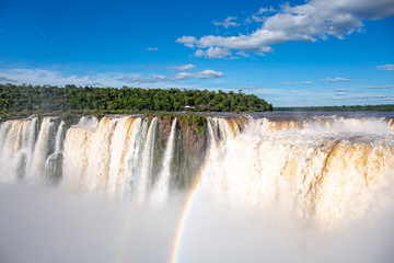 View to Devil`s Throat and Salto Union with rainbow, rainforest, blue sky and  white clouds, Iguazu Falls, Argentina