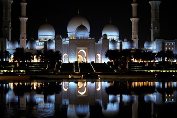 sheikh zayed mosque at night reflected in water