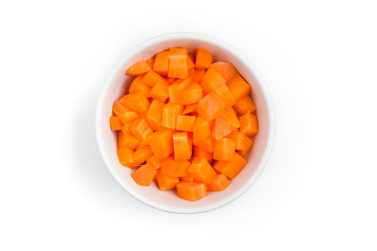 Top view (flat lay) of chopped carrots in a white ceramic bowl on white background with clipping path.