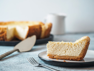 Plate with piece of cheesecake on tabletop. Classic homemade cheesecake with Shallow DOF. Copy...