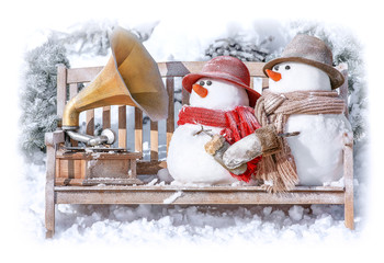 Greeting card Merry Christmas and Happy New Year with cute snowman on a bench against