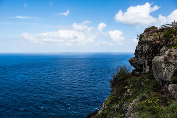 Fototapeta premium Cliff with blue ocean water and white clouds 