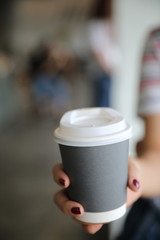 Fototapeta na wymiar take home hot cappuccino or Latte art coffee made from milk with female hand