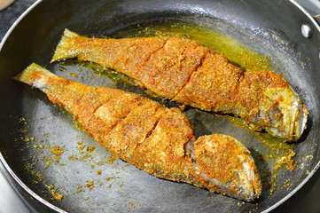 Tasty fried fish pieces on frying pan