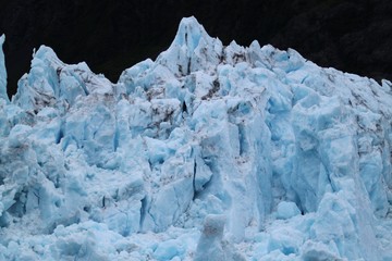 Fototapeta na wymiar Beautiful Blue Glacier Ice Shot On A Dark Background.