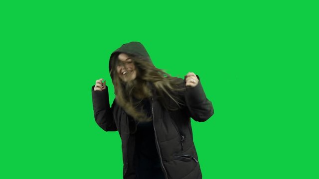 Happy girl playing around with the jacket in front of the green screen