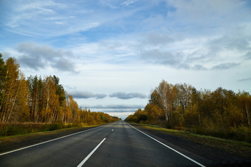 Track from the car window and white clouds on blue sky. Natural landscape