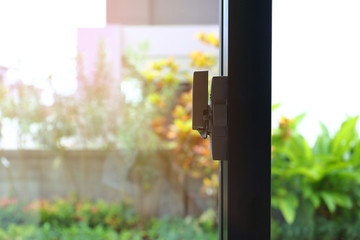 security lock on glass window with green garden outside view of home