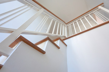 brown wooden stair with white steel balustrade and hardwood handrail banister in modern residential...