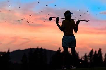 silhouette of woman golfer in an action of relxa and enjoy after hit a golf ball away to fairway in...