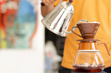 barista dripping coffee. Barista holds a hot water in pouring to coffee making.