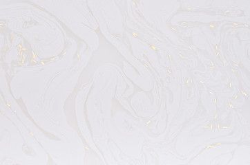 Fototapeta na wymiar Soft light white abstract background of liquid paint and gold glitter on surface as abstract texture.