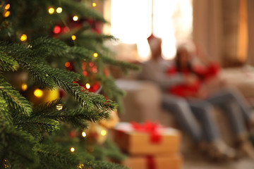 Fototapeta na wymiar Couple on sofa indoors, focus on Christmas tree