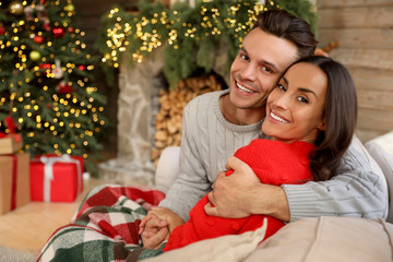 Fototapeta na wymiar Happy young couple in living room decorated for Christmas