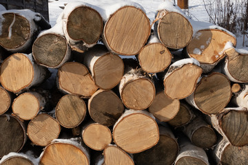 Fototapeta premium Background of dry chopped firewood logs stacked up on top of each other