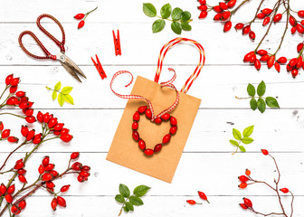 Beautiful heart made of rose hip fruits as a small decoration for gift bag. Top view. Decorative handmade concept.
