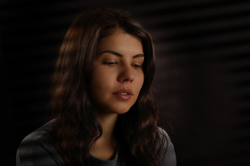 Fototapeta premium Portrait of a nice brunette girl with downcast eyes