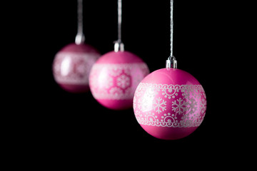 Traditional pink christmas balls on black background.