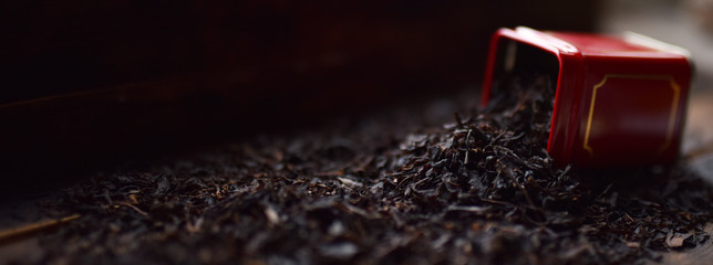 black tea in a red tin on a dark background