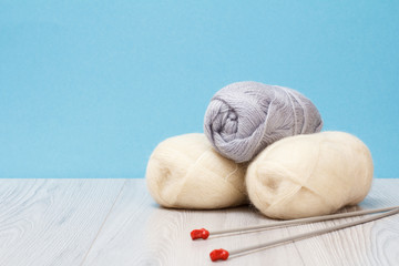 Obraz na płótnie Canvas Woolen yarn for knitting. Balls of natural wool yarn and knitting needles
