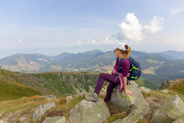 Woman in tourist clothes gaze into the distance in the mountains. High Tatras. Slovakia.