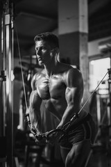 Fototapeta na wymiar muscular bodybuilder guy workout in gym