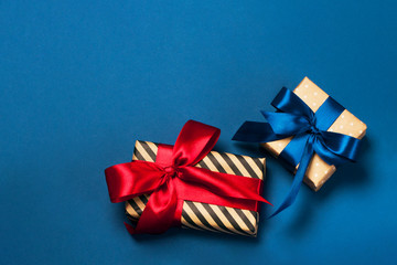 Luxuriously wrapped gifts with lush ribbon. Trendy red and blue colors. Merry Christmas, St. Valentine's Day, Happy Birthday and other holidays concept.