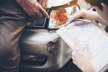 Insurance agent working during on site car accident claim process - people and car insurance claim...
