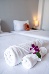 Fototapeta na wymiar Towel with Orchid on bed decoration in bedroom interior for hotel customer.