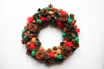 Fototapeta na wymiar Modern Christmas wreath made from natural materials on a white background. Season's greetings. Festive decor.