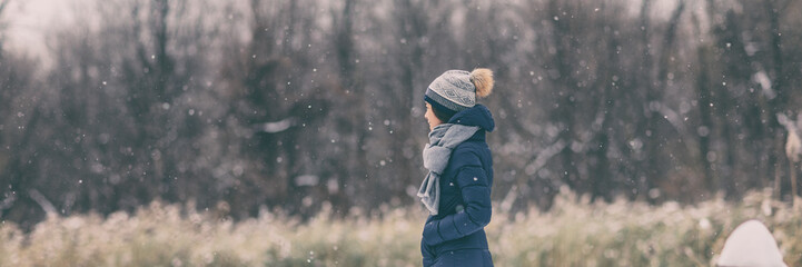 Winter snow forest walk young woman wearing cold weather coat jacket walking in outdoor nature...