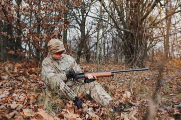 Fototapeta premium Hunter in uniform with a hunting rifle. Hunting Concept