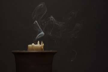 Smoke from a wax candle on a dark background. Concept of divination, magic, ritual. Copy space.