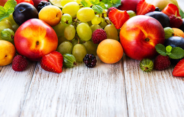 Naklejka na ściany i meble Fresh summer fruits and berries on a white wooden table