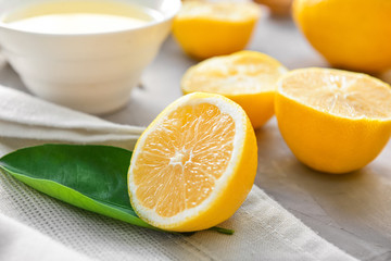 Ripe lemons and bowl with juice on table