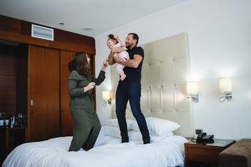Man, woman and girl in hotel room.