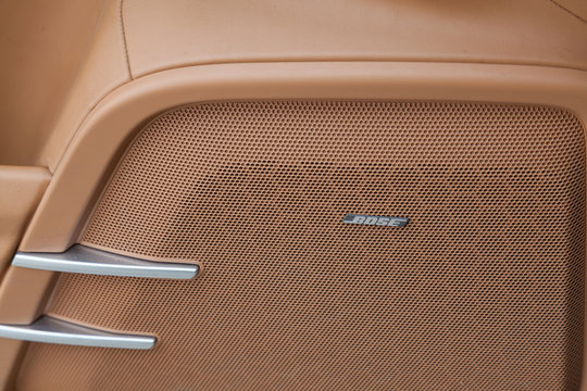 The interior of the car Porsche Cayenne Diesel 958 2012 year with a view of the door speaker panel Bosel and multimedia system with light brown leather trim