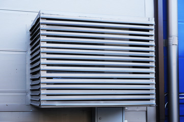 The air conditioner installed on the street is protected by a metal casing.