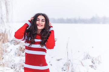 Winter holidays concept. Arabic woman in stylish look at snowy day outside 