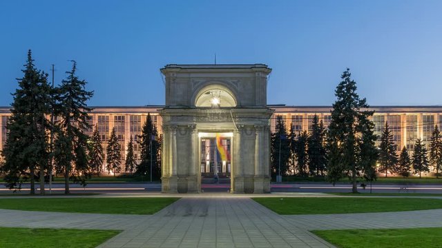 Zoom out: Chisinau, Moldova - the Triumphal arch at sunset. Timelapse of the Triumphal arch and Moldova Government House. Establishing shot of the city of Chisinau and Moldova. Day to Night timelapse