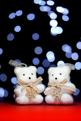 Christmas decoration with little white bears on blurred background of lights.