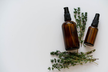 Natural health products flat lay photo with copy space on left side, glass bottles and fresh thyme herb.